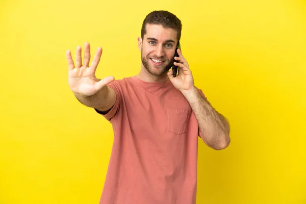 Handsome Blonde Man Using Mobile Phone Isolated Background Counting Five — Stock Photo, Image