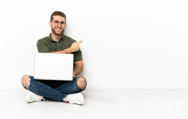 stock image Young man sitting on the floor pointing back
