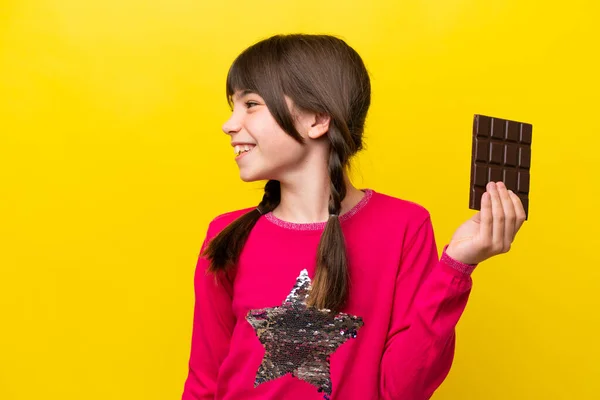 Malá Kavkazská Dívka Čokoládou Izolované Žlutém Pozadí Při Pohledu Straně — Stock fotografie