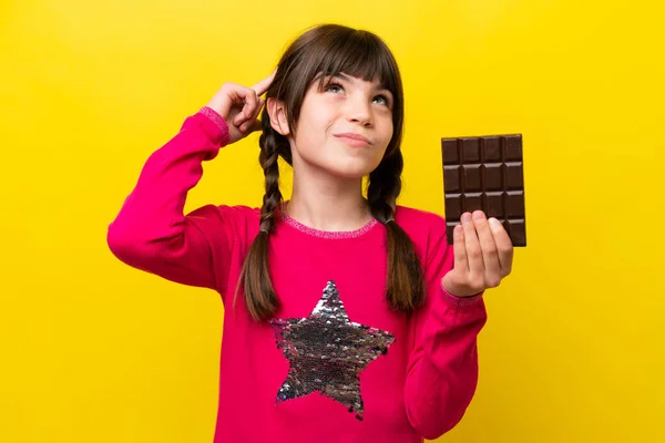 Malá Kavkazská Dívka Čokoládou Izolované Žlutém Pozadí Mají Pochybnosti Myšlení — Stock fotografie
