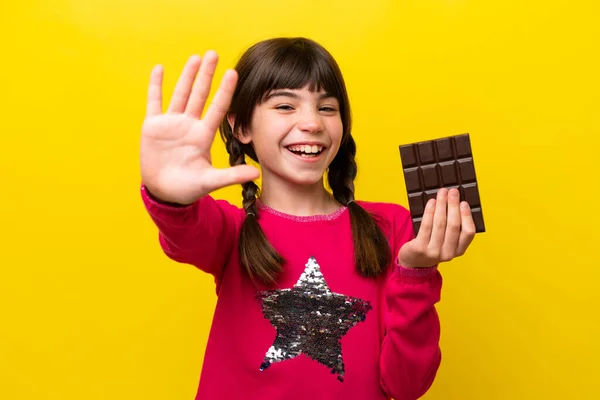 stock image Little caucasian girl with chocolat isolated on yellow background counting five with fingers