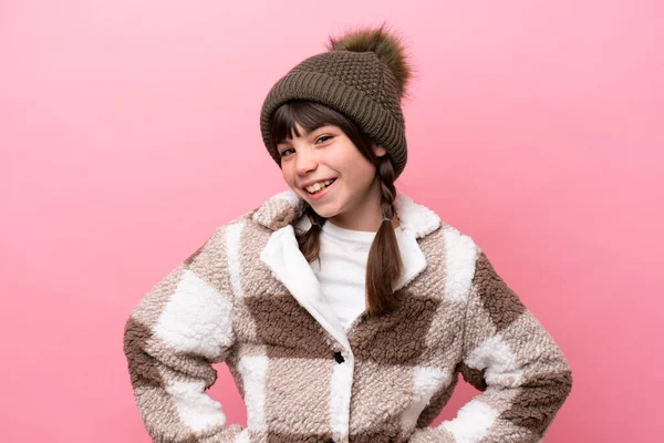 小高加索女孩 穿着冬季夹克 背景粉色 双手叉腰 面带微笑 — 图库照片