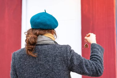 Esmer kadın evin anahtarlarını arka tarafta tutuyor.