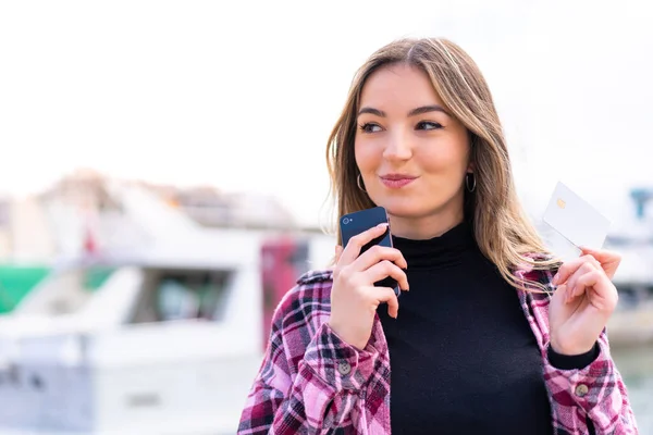 Młoda Ładna Rumuńska Kobieta Zewnątrz Kupuje Pomocą Telefonu Komórkowego Kartą — Zdjęcie stockowe