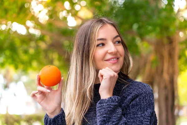 Молодая Красивая Румынская Женщина Держит Апельсин Открытом Воздухе Думая Идее — стоковое фото