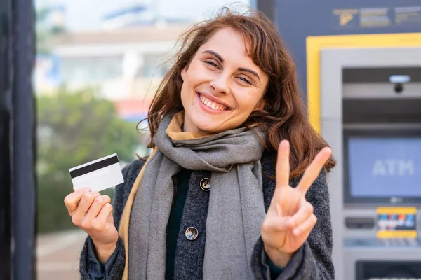 Mujer Morena Sosteniendo Una Tarjeta Crédito Aire Libre Sonriendo Mostrando —  Fotos de Stock