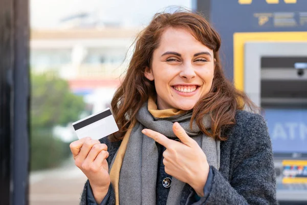Mujer Morena Sosteniendo Una Tarjeta Crédito Aire Libre Señalándolo —  Fotos de Stock
