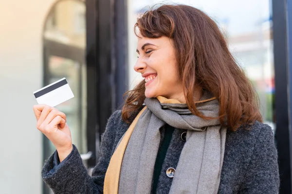 Μπρουνέτ Γυναίκα Κρατώντας Μια Πιστωτική Κάρτα Εξωτερικούς Χώρους Ευτυχισμένη Έκφραση — Φωτογραφία Αρχείου