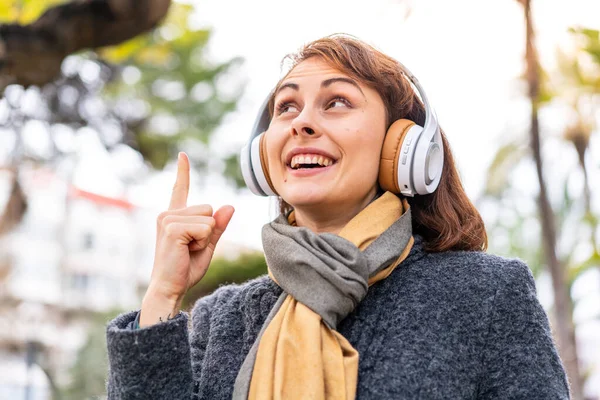 Μελαχρινή Γυναίκα Ακούει Μουσική Ακουστικά Εξωτερικούς Χώρους Σκοπό Συνειδητοποιήσει Λύση — Φωτογραφία Αρχείου