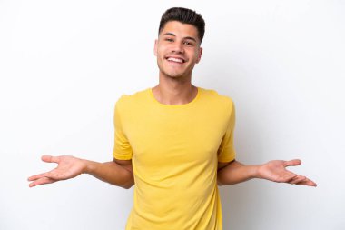 Beyaz arka planda izole edilmiş genç beyaz adam mutlu ve gülümsüyor.