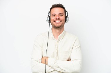 Tele pazarlamacı, beyaz arka planda izole edilmiş bir kulaklıkla çalışan beyaz bir adam kollarını ön tarafta çapraz tutuyor.