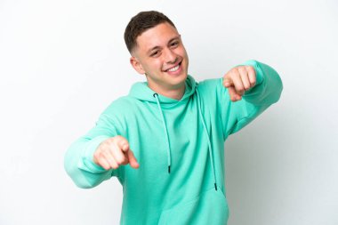 Beyaz arka planda izole edilmiş genç Brezilyalı adam mutlu bir ifadeyle öne bakıyor.