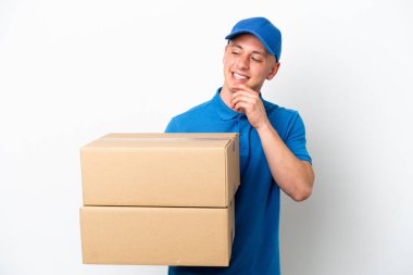 Genç teslimatçı Brezilyalı adam, beyaz arka planda, yan tarafa bakıp gülümsüyor.
