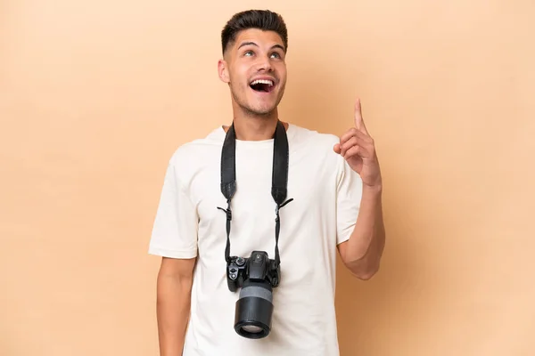 Young Photographer Caucasian Man Isolated Beige Background Pointing Surprised — Stock Photo, Image