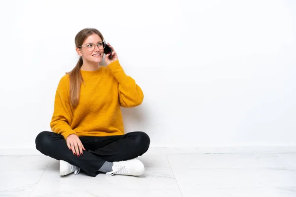 Mladá Běloška Sedí Podlaze Izolovaná Bílém Pozadí Udržuje Konverzaci Mobilním — Stock fotografie