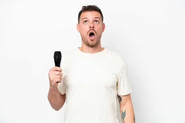 Młody Biały Piosenkarz Człowiek Podnosząc Mikrofon Odizolowany Biały Tło Patrząc — Zdjęcie stockowe