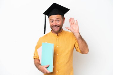 Beyaz arka planda izole edilmiş orta yaşlı beyaz bir adam mutlu bir ifadeyle selamlıyor.