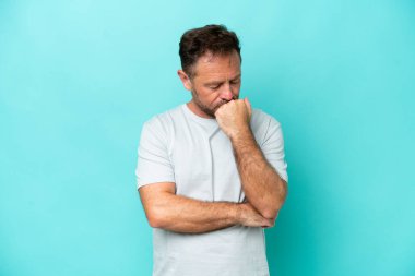 Mavi arka planda soyutlanmış orta yaşlı beyaz bir adam şüpheleri var.