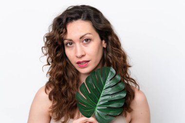 Beyaz arka planda, elinde palmiye yaprağı olan beyaz bir kadın. Portreyi kapat