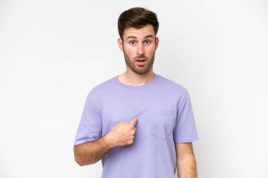 Beyaz arka planda izole edilmiş genç beyaz adam kendini işaret ediyor.