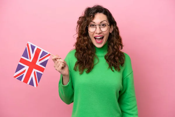 Mladá Běloška Drží Anglickou Vlajku Izolovanou Růžovém Pozadí Překvapením Šokovaným — Stock fotografie