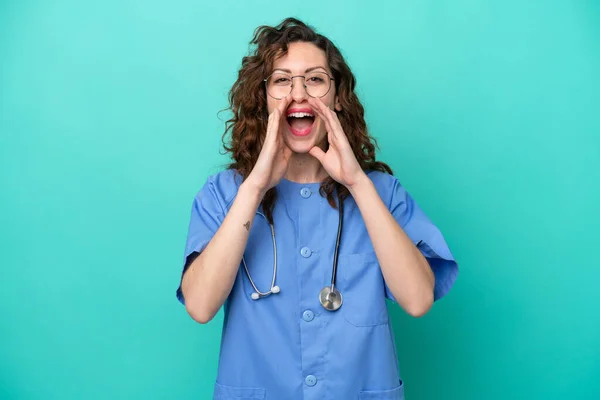 青い背景の叫びと何かを発表に隔離された若い看護師の白人女性 — ストック写真