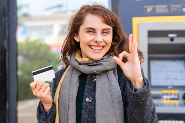 Mujer Morena Sosteniendo Una Tarjeta Crédito Aire Libre Mostrando Signo —  Fotos de Stock