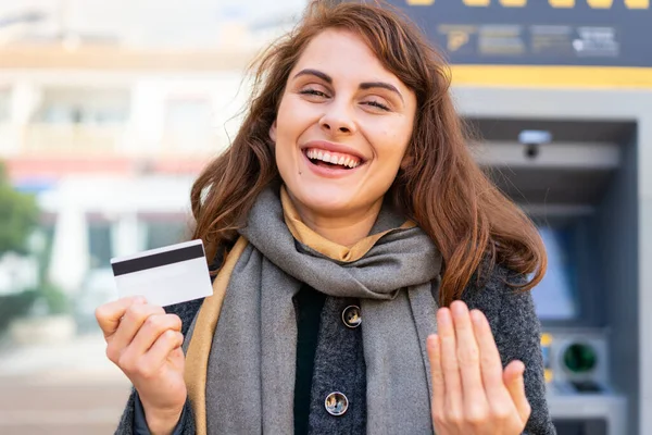 Brunetka Trzymająca Kartę Kredytową Świeżym Powietrzu Zapraszająca Wyjścia Rękami Cieszę — Zdjęcie stockowe