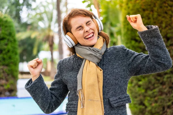 Bruneta Žena Poslouchá Hudbu Sluchátky Venku Slaví Vítězství — Stock fotografie