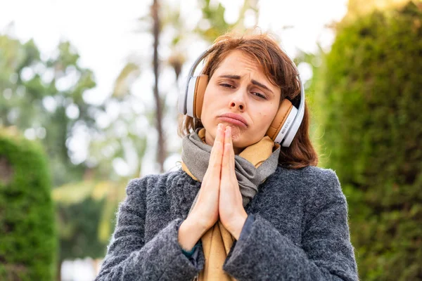 Mujer Morena Escuchando Música Con Auriculares Aire Libre Mantiene Palma — Foto de Stock