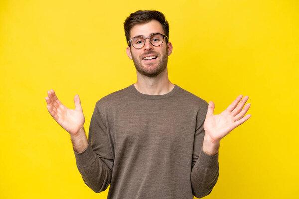 Young caucasian man isolated on yellow background smiling a lot