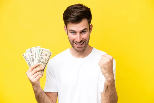 Jonge Kaukasische Man Neemt Veel Geld Geïsoleerd Gele Achtergrond Vieren — Stockfoto