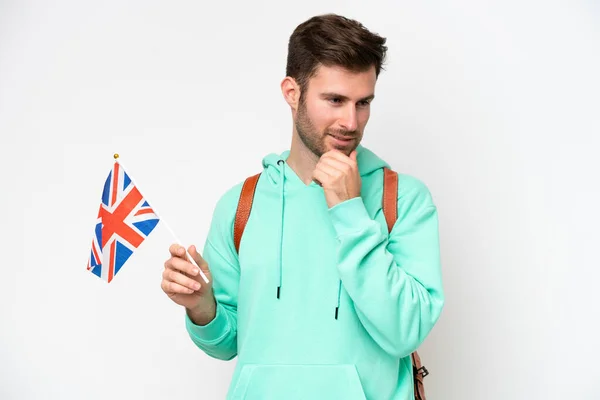 年轻的学生高举一面英国国旗 背景是白色的 面带微笑地看着旁边 — 图库照片