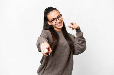 İzole edilmiş beyaz arka plan üzerinde genç bir Arap kadın mutlu bir ifadeyle ön tarafı işaret ediyor