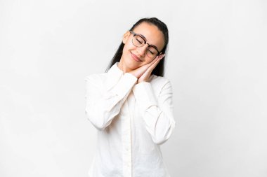 İzole edilmiş beyaz arka plan üzerinde genç bir Arap kadın uyku jesti yapıyor.