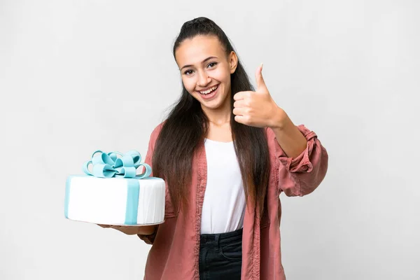 stock image Young Arabian woman holding birthday cake over isolated white background with thumbs up because something good has happened