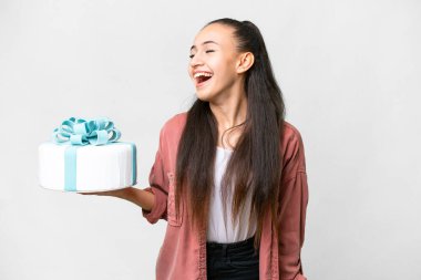 Genç Arap kadın, izole edilmiş beyaz arka planda doğum günü pastası tutuyor ve yan yana gülüyor.