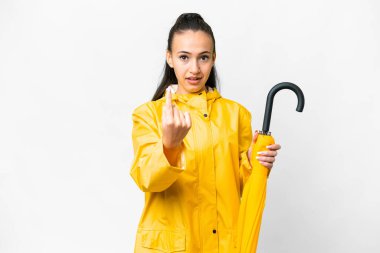 Yağmura dayanıklı ceketli ve şemsiyeli genç bir Arap kadın, izole edilmiş beyaz arka planda geliyor.