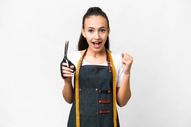 Genç terzi kadın izole edilmiş beyaz arka planda galibiyeti kutluyor.