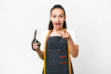 Tecrit edilmiş beyaz bir geçmişi olan genç terzi kadın şaşırmış ve ön tarafı işaret ediyor.