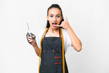 İzole edilmiş beyaz arka planda genç bir terzi kadın telefon jesti yapıyor. Bana geri dönüş işareti ver.