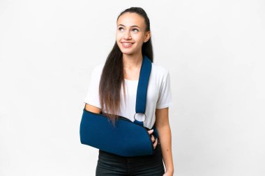 Kırık kollu genç bir Arap kadın ve izole edilmiş beyaz bir arka plan üzerinde askısı var.