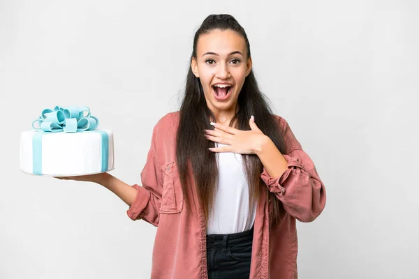 Stock image Young Arabian woman holding birthday cake over isolated white background surprised and shocked while looking right