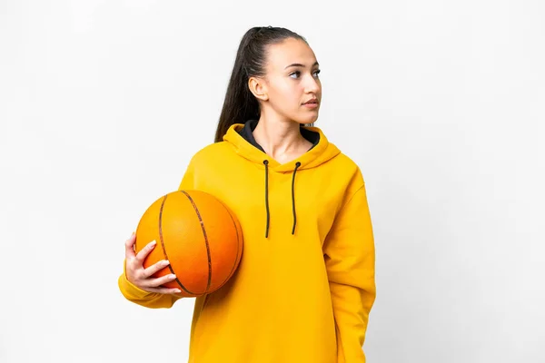若いですアラビア人女性プレイバスケットボール上の隔離された白い背景見ますザ側 — ストック写真
