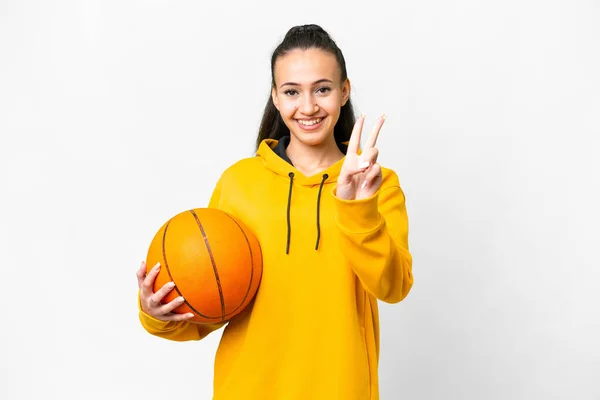 若いですアラビア人女性遊びバスケットボール上の隔離された白い背景笑顔とショー勝利サイン — ストック写真