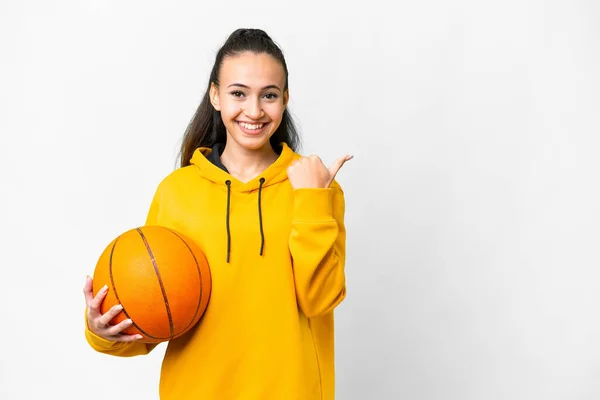 プロダクトを提示するために側面を指す隔離された白い背景の上にバスケットボールをしている若いアラビア人女性 — ストック写真