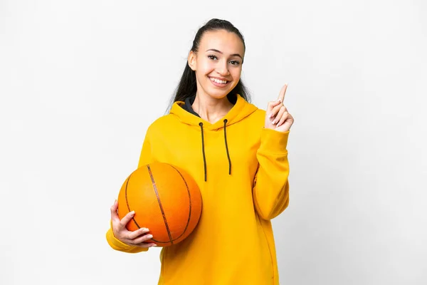 若いですアラビア人女性遊びバスケットボール上の隔離された白い背景ショーと持ち上げる指の記号で最高の — ストック写真