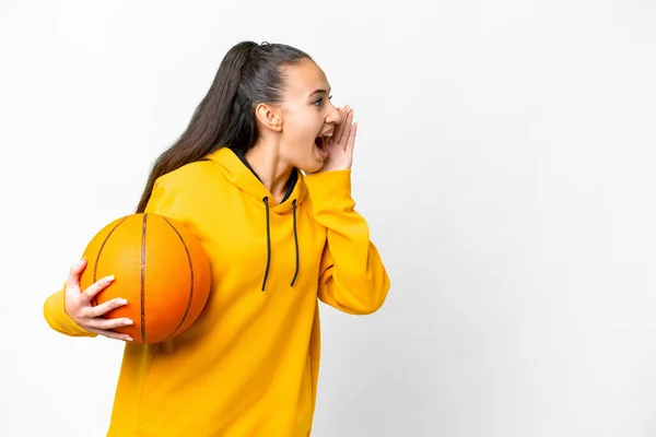 若いですアラビア人女性プレイバスケットボール上の隔離された白い背景叫びとともに口を大きく開きますザ側 — ストック写真