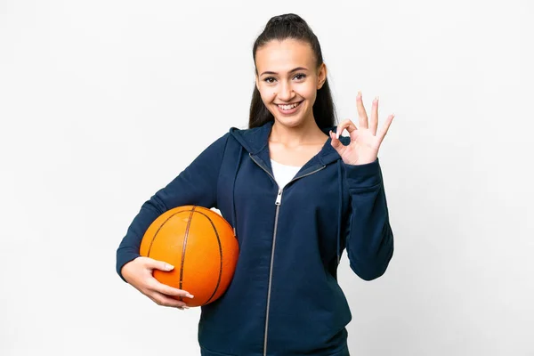 年轻的阿拉伯女子过孤独的白人背景打篮球和做Ok标志 — 图库照片