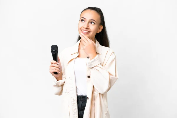 Joven Cantante Mujer Recogiendo Micrófono Sobre Fondo Blanco Aislado Mirando — Foto de Stock